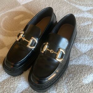 Black leather loafers with gold horsebit hardware, size 9, small mark.